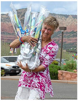 smiling woman holding several umbrellas